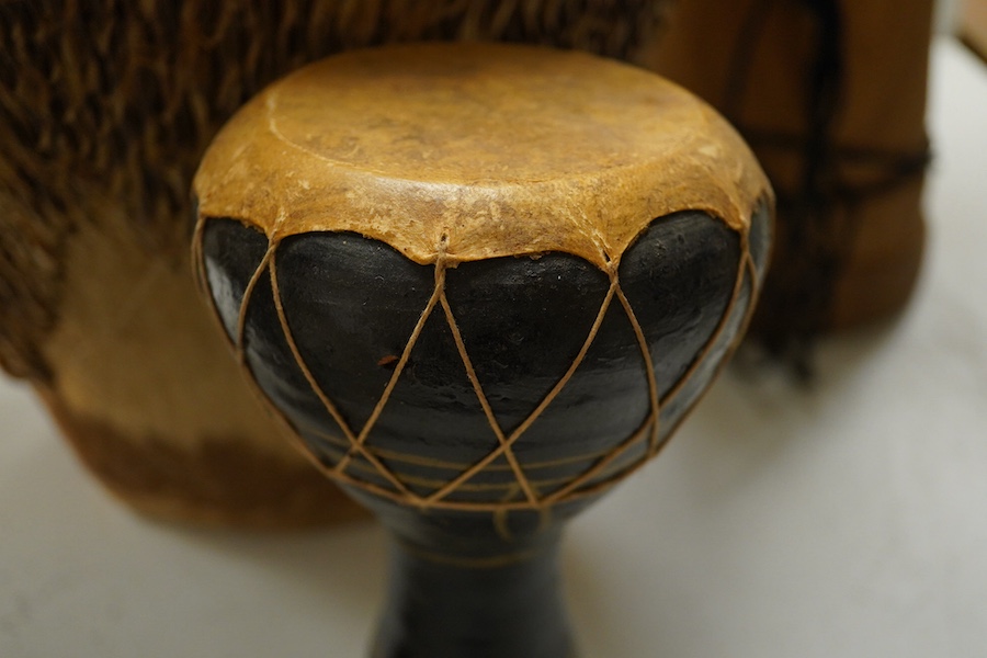 Five African drums; a Djembe, 50cm high, together with four others, including a pottery triple drum, etc. Condition - fair to good.